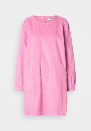 Abito in velluto a coste rosa con maniche lunghe, scollatura tonda e due tasche frontali. Presenta un tessuto testurizzato e una chiusura con zip sul retro.