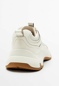 Sneaker bianco con tomaia in pelle texturizzata, dotata di un retro imbottito, suola in gomma beige e linguetta sul tallone per una facile calzata.