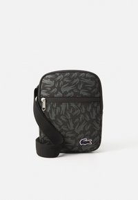 Borsa a tracolla nera con un motivo testurizzato di mani, chiusura con zip e un accento logo bianco. Realizzata in tessuto durevole con una tracolla regolabile.