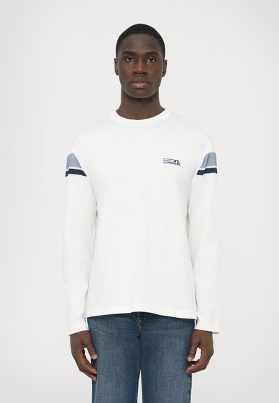 Λευκό T-shirt με μακριά μανίκια, με ναυτικό και ανοιχτό μπλε ριγέ διακοσμητικά στα μανίκια, με μικρό λογότυπο στο στήθος. Μαλακό βαμβακερό ύφασμα.