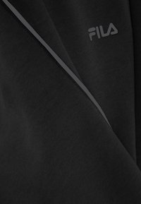 Zwarte sweatshirt van zachte stof, met een FILA-logo in lichtgrijs en een contrasterende grijze streep langs de naad.