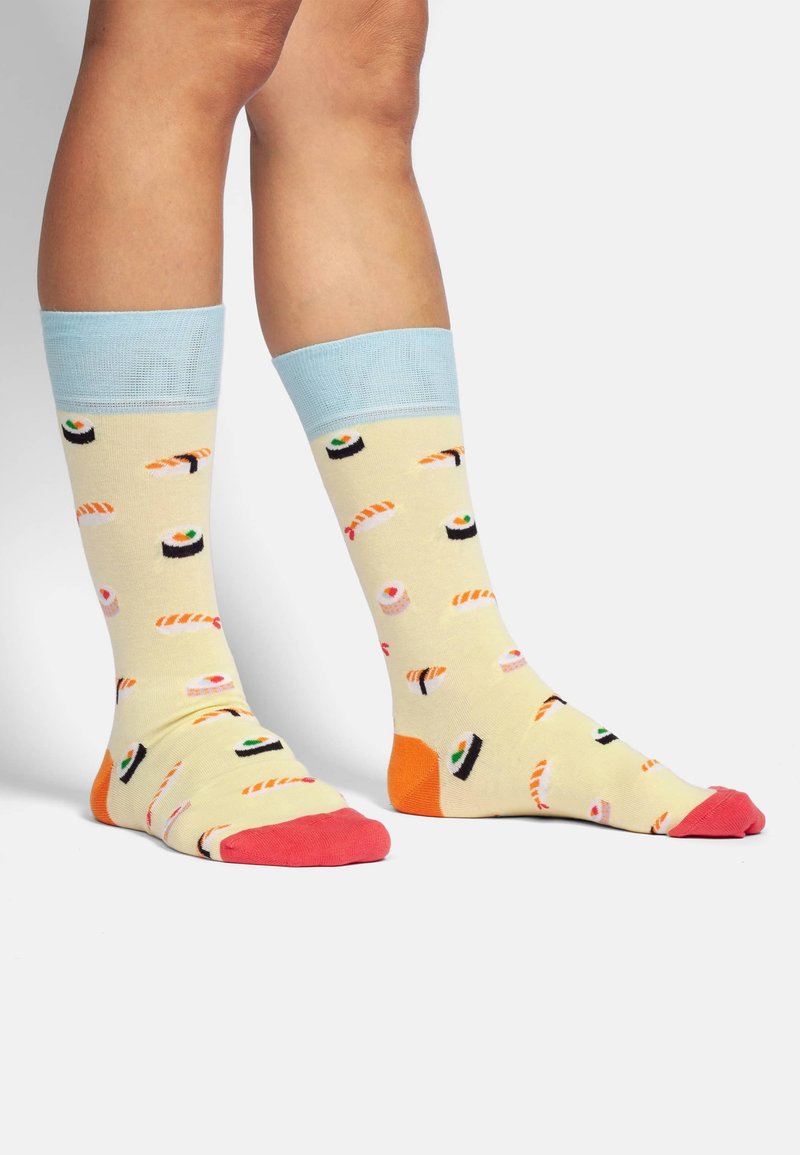 Kniehoge sokken van zacht materiaal in het geel met sushi-patronen. Lichtblauwe boord, roze teen- en hielaccenten, en een speels ontwerp overal.