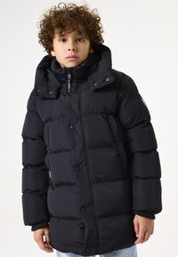 Schwarze Daunenjacke mit hohem Kragen, großen, gesteppten Abschnitten und Knopfverschlüssen. Das Material ist glatt und glänzend mit einem Design im Cabin-Stil.