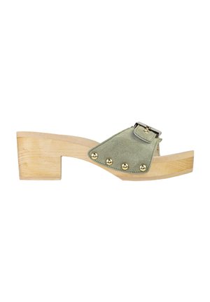 Sandalo con tacco basso in legno, cinturino in camoscio verde oliva, borchie dorate e fibbia in metallo su sfondo bianco.