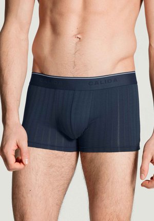 Marineblaue Herren-Boxershorts aus einem glatten Stoff mit vertikalen Nadelstreifen, ausgestattet mit einem breiten Bund, der in kontrastierenden Farben mit "CALIDA" gebrandet ist.
