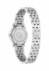 Sudraba nerūsējošā tērauda pulkstenis ar astoņu stūru korpusu, saistītu aproci, gludu tekstūru un zīmola logotipu uz korpusa aizmugures.