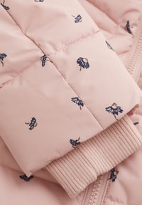Veste rose rembourrée ornée d'une broderie florale marine, avec des poignets en tricot côtelé et un matériau extérieur texturé avec un détail zippé.