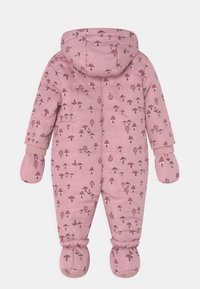 Un traje de nieve rosa para bebés con mitones, botines, capucha y un patrón de setas marrones por toda la superficie.