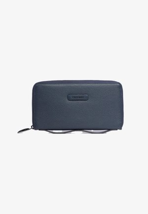 Marineblauw leren portemonnee met een gestructureerde afwerking, ritssluiting en een metalen merkembleem aan de voorkant. Slank, rechthoekig ontwerp met contrasterende accenten.