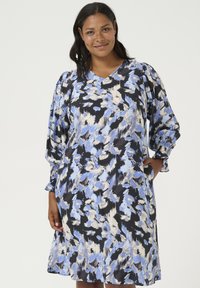Vestido floral con un patrón azul y negro, escote en V y mangas largas fruncidas con puños elásticos. Tela ligera, corte relajado.