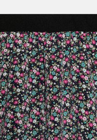 Blomsterpryntet stoff med små rosa, hvite og mintfargede blomster på en mørk bakgrunn. Elastisk svart midjebånd, plisserte detaljer.