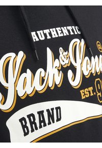 Felpa nera con cappuccio caratterizzata da testo bianco e dorato con "Jack & Jones", "Authentic" e "Brand", evidenziando un design grafico vintage.