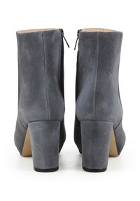 Stivaletti in suede grigio con tacco medio a blocco, dotati di punte chiuse e chiusura con zip sul retro per una facile calzata.