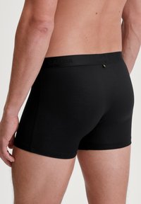 Zwarte katoenen boxershorts met een fitted ontwerp, met een soepele tailleband waarop de merknaam "Calida" in een subtiele structuur is weergegeven.