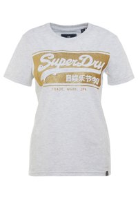 Světle šedé bavlněné tričko s kulatým výstřihem, s velkým zlatým a bílým logem "SuperDry" vpředu. Krátké rukávy.