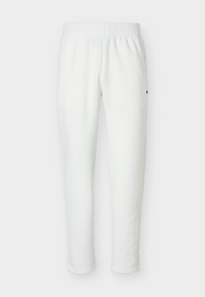 Pantaloni jogger con vita elastica bianca, gambe affusolate e piccolo logo ricamato sul lato sinistro vicino all'anca.