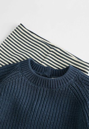 Marineblauer gerippter Strickpullover mit runder Ausschnitt, kombiniert mit einem crème- und marineblau gestreiften Stoff. Beide Teile sind gefaltet und auf einem hellen Hintergrund präsentiert.