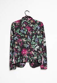 Chemise à manches longues fleurie, fond noir, motifs de fleurs roses, vertes et bleues, tissu doux, ourlet incurvé et design boutonné.