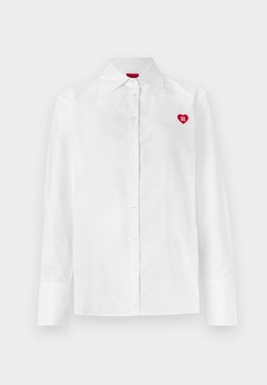 White button-up shirt with long sleeves, classic collar, and a red heart logo on the left chest. Smooth texture and tailored fit.