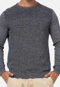 Szary sweter dziany z fakturowaną górną częścią, okrągłym dekoltem i ściągaczami na rękawach. Materiał wydaje się miękki i lekko rozciągliwy.