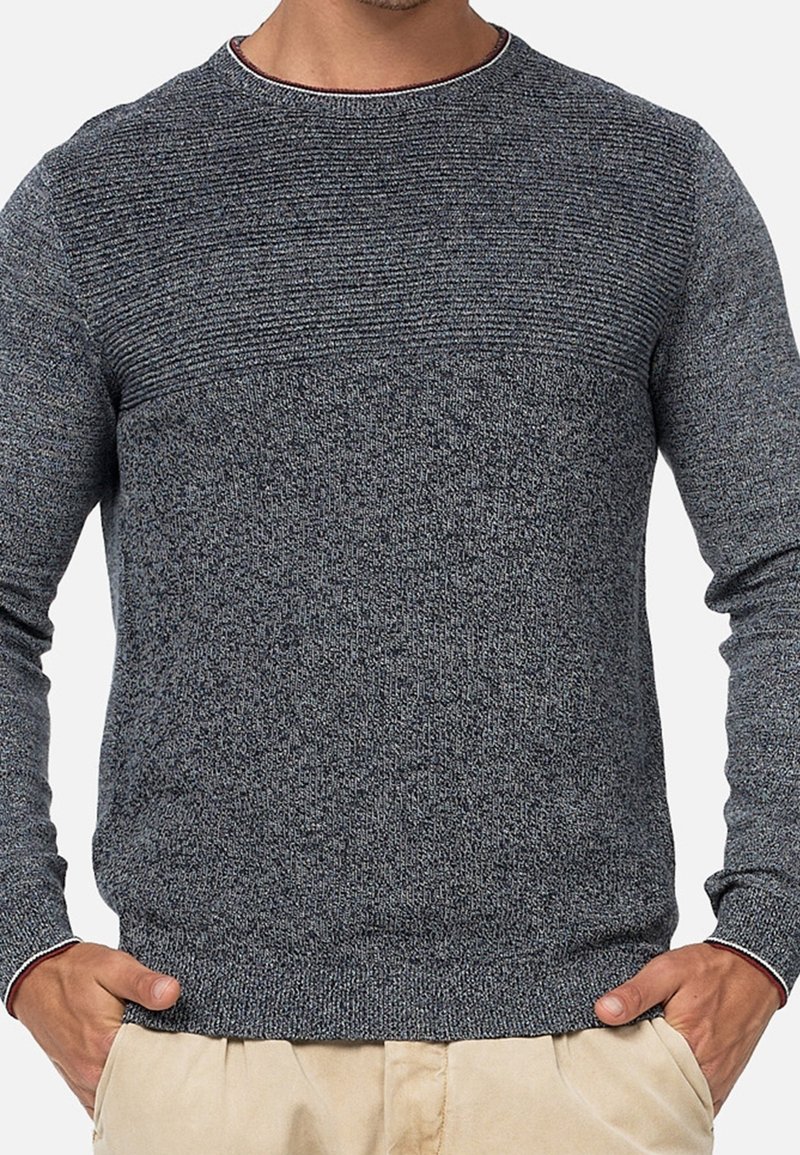 Szary sweter dziany z fakturowaną górną częścią, okrągłym dekoltem i ściągaczami na rękawach. Materiał wydaje się miękki i lekko rozciągliwy.