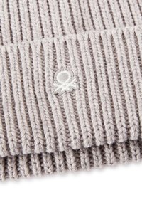 Pletený šál v světle šedé barvě s ribbovanou texturou a malým vyšitým logem. Měkký materiál s výraznými svislými pruhy.