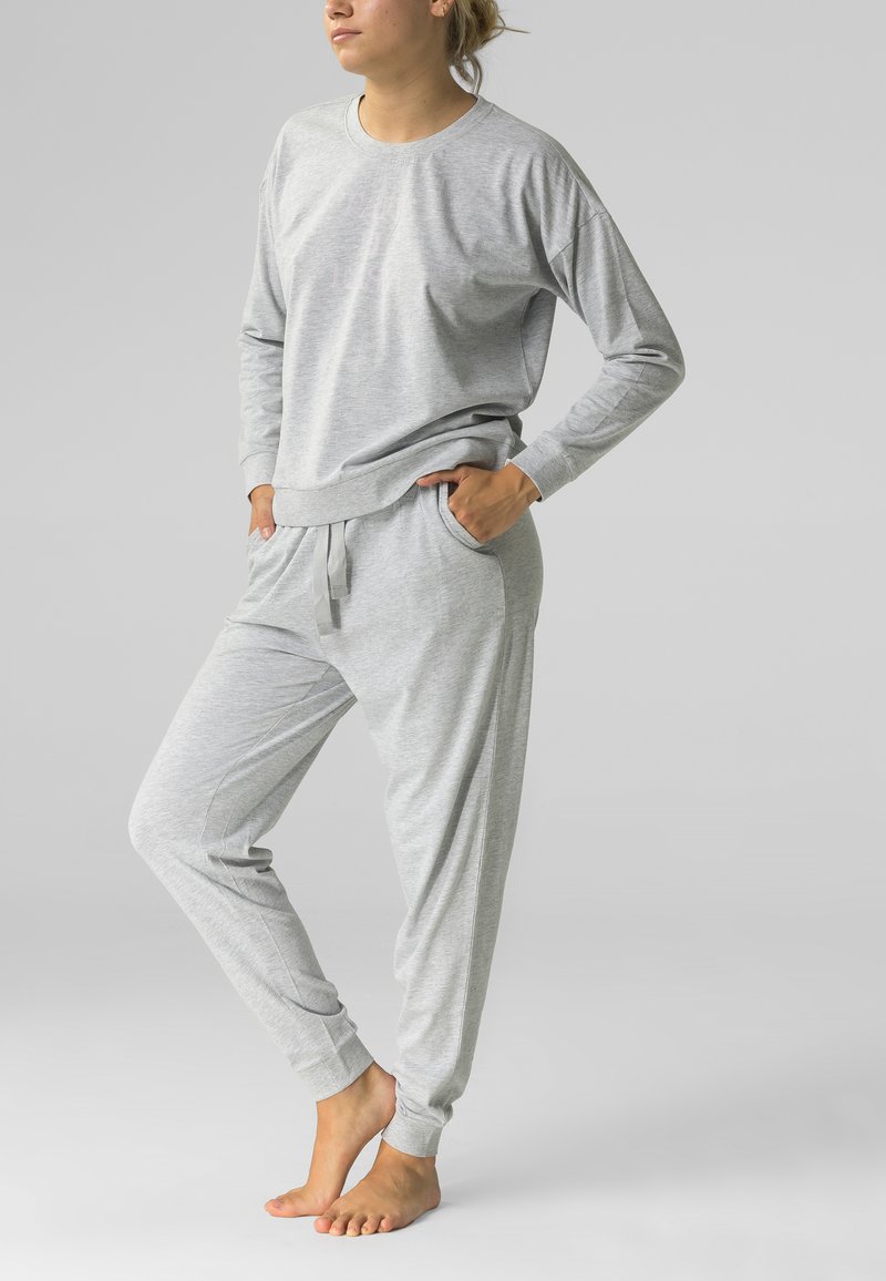 Szary zestaw odzieży domowej składający się z długiego rękawa bluzki oraz zwężających się spodni, wykonany z miękkiego materiału o luźnym kroju i elastycznym pasie.