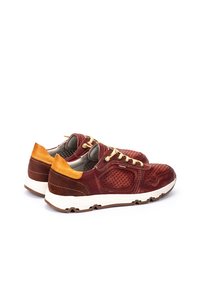 Zapatillas de ante rojo con diseño perforado, detalles en color beige y suela blanca. Cuenta con cordones amarillos y un tobillo acolchado para mayor comodidad.