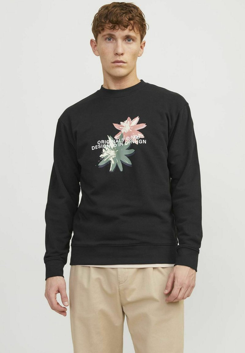 Sudadera negra con un gráfico floral en rosa y verde, y el texto "ORIGINALS ©1990 DISEÑADO EN COPENHAGUE" en el frente. Material de algodón.