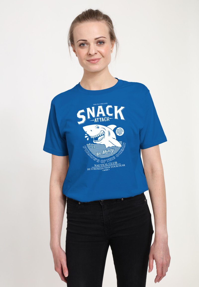 Camiseta de algodón azul con un gráfico blanco de un tiburón y el texto "SNACK ATTACK", con un tema náutico, mangas cortas y escote redondo.