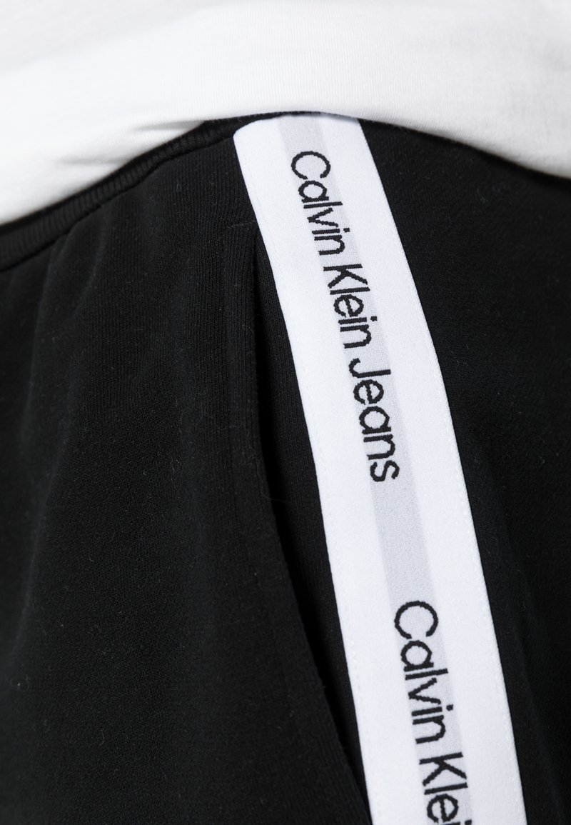 Herren Trainingsanzüge | Calvin Klein Jeans CONTRAST TAPE HWK Jogginghose ck black/schwarz - NU25013 Herren Trainingsanzüge | Calvin Klein Jeans CONTRAST TAPE HWK Jogginghose ck black/schwarz - NU25013