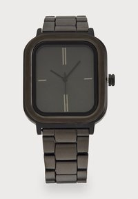 Montre noire avec un boîtier rectangulaire, un cadran noir mat, des index horaires en argent et un bracelet en acier à maillons. Comprend une couronne sur le côté.