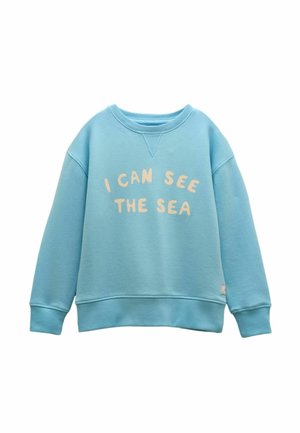 Light blue sweatshirt with ribbed cuffs and hem, featuring beige text "I CAN SEE THE SEA" across the front.