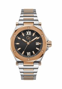 Oktagonal ur med sort urskive, roseguldfarvede accenter og sølv rustfrit stålarmbånd. Har romerske tal og et datovindue.