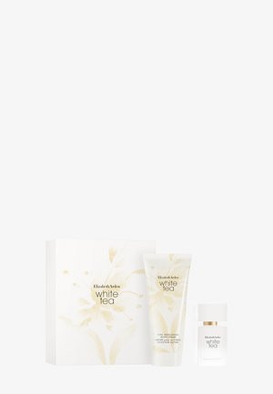 Set de regalo que incluye una caja blanca con acentos florales dorados, un tubo crema y una botella de vidrio, todos etiquetados como "Té Blanco" de Elizabeth Arden.