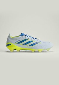 Crampon de football Adidas Predator blanc et jaune néon avec des bandes bleues, des lacets et des crampons translucides sur un fond uni.