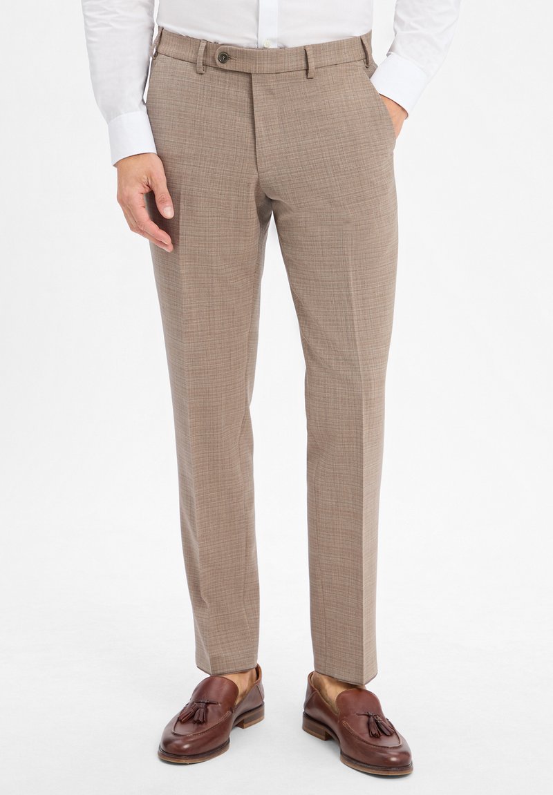 Beige karierte Hose mit schlanker Passform, mit Knopfverschluss, seitlichen Taschen und einer glatten Stofftextur. Kombiniert mit braunen Mokassins.