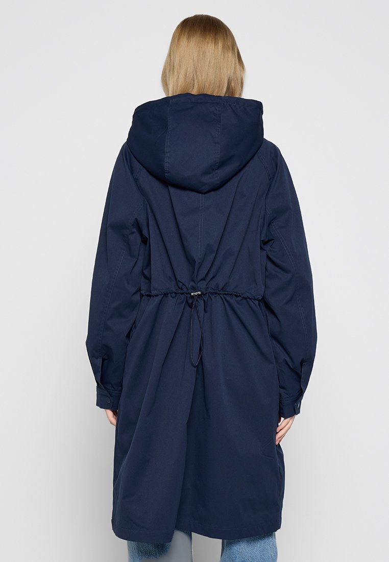 Marineblaue wasserdichte Parka mit Kapuze, tailliertem Schnitt, langen Ärmeln und einem Design, das bis zur Mitte des Oberschenkels reicht, mit einem Kordelzug am Rücken.