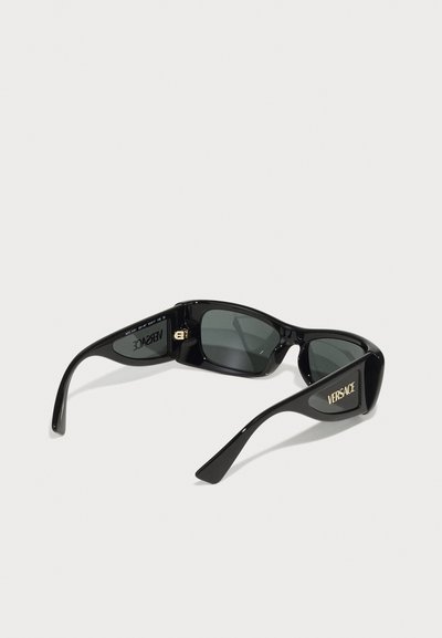 Melni saulesbrilles ar spīdīgu apdari, taisnstūra lēcām un zelta "VERSACE" logo sānos. Izstrādātas ar elegantiem, plāniem kātiem.