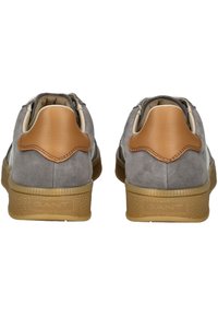 Sneakers in camoscio grigio con un accento sul tallone in pelle marrone chiaro, suola in gomma e dettagli testurizzati sul bordo della suola. Branding sul tallone.