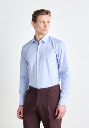 Camicia button-up azzurro chiaro con motivi sottili, maniche lunghe e colletto standard, abbinata a pantaloni borgogna con vita elasticizzata.