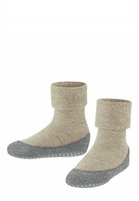 Calzini lavorati a maglia beige con suola in feltro grigia. Presentano un polsino pieghevole e una parte superiore texturizzata, che garantiscono una vestibilità sicura e comfort.