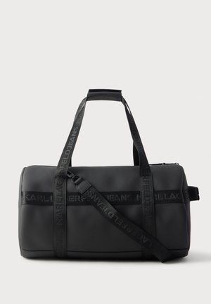 Sac polochon rectangulaire noir avec deux poignées de transport et une bandoulière ajustable, avec un marquage embossé KARL LAGERFELD JEANS sur les sangles.