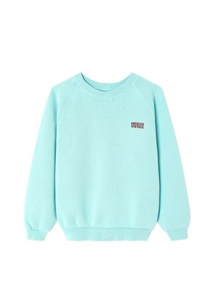 Světle modrá mikina s kulatým výstřihem a dlouhými rukávy s malým tmavě červeným textem "American Vintage" v horní levé části hrudi.