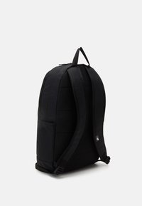 Black backpack with padded structure, adjustable straps, and side pocket. Durable fabric with a smooth texture and subtle branding detail.