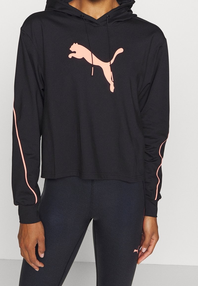 Felpa nera corta realizzata in tessuto liscio, con un grande logo Puma rosa e dettagli rosa lungo le maniche. Tasca a marsupio frontale.
