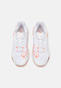 Scarpe da ginnastica bianche con accenti rosa, tomaia in rete, design testurizzato e chiusura con lacci. Presenta il logo PUMA sui lati e sulla linguetta.