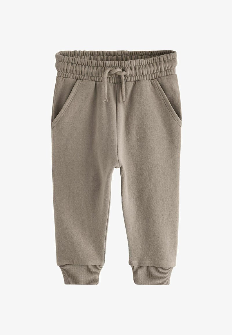 Világos bézs színű, puha anyagból készült melegítőnadrág, elasztikus derékkal és zsinórral, két oldalsó zsebbel és bordázott mandzsettákkal.