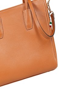 Orange textured leather handbag with two top handles and a detachable shoulder strap. Features a small Italian flag accent.