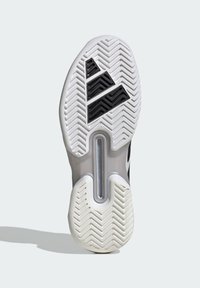 Suela de zapato que presenta una base de goma blanca con un patrón de espiga, acentos de goma negra y una sección central translúcida.